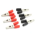 Pezzi di prova con morsetti in rosso e nero, strumenti di laboratorio per test elettrici.