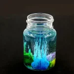 Contenitore di vetro con liquido colorato e reazione luminosa.