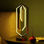 Lampada decorativa LED con design geometrico e luce calda.