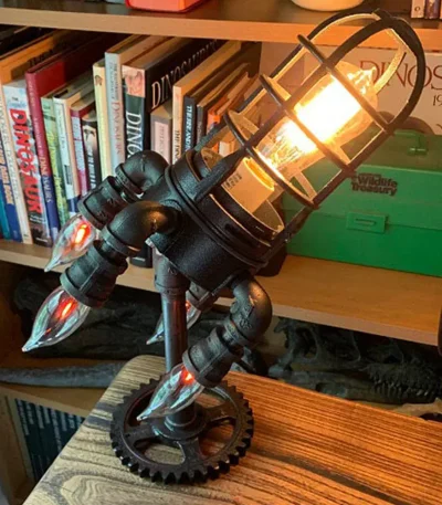 Lampada decorativa in stile steampunk con elementi scientifici, illuminazione calda e design vintage, perfetta per ambienti studi o decorazioni a tema scientifico.