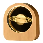 Vaso decorativo con pianeta Saturno in resina e LED, perfetto come oggetto scientifico e decorativo, illuminato con luci calde, ideale per appassionati di astronomia e design.