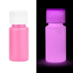 Pillole fluorescenti rosa e viola, visibili in luce normale e sotto luce UV, ideali per decorazioni scientifiche e effetti luminosi.