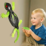Bambino che gioca con una lucertola robotica educativa, dotata di luci e movimento, appesa al muro. Perfetta come decorazione scientifica interattiva per ambienti educativi e ludici.