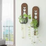 Supporto decorativo per piante con contenitori in vetro e elementi scientifici in metallo, ideale per arredare con stile e originalità ambienti interni.