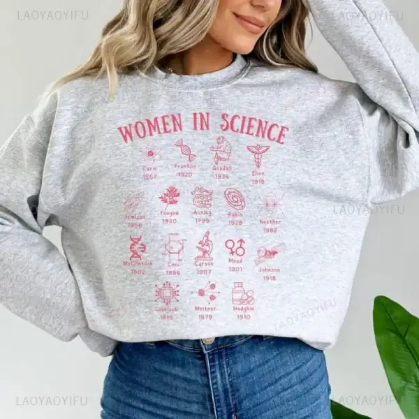 T-shirt grigia con illustrazioni e nomi di donne scienziate famose, evidenziando il loro contributo alla scienza.