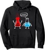 Felpa nera con disegni di un becher e un erlenmeyer che si confrontano, con il testo "I think you're OVERREACTING" in un fumetto. Design divertente e originale, perfetto per appassionati di scienza e.