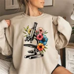 Microscopio con fiori colorati per decorazione scientifica e botanica. Perfetto per gli amanti delle scienze e della natura, questa illustrazione combina la ricerca e la bellezza naturale.