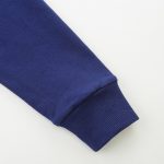 Dettaglio di una manica di una maglietta blu navy con polsino a coste, tessuto morbido e di alta qualità, perfetta per un look casual e comodo.