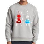 Maglione grigio con disegni di un becher rosso arrabbiato e una provetta blu, con fumetto "Sei troppo sopraffatto". Design divertente e scientifico, perfetto per appassionati di chimica.