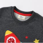 Maglietta grigia con stampa di un razzo e stelle colorate, perfetta per appassionati di scienza e tecnologia.