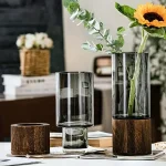 Vasi decorativi in vetro con base in legno, ideali per esposizione di fiori e piante, perfetti come oggetti scientifici e decorazioni eleganti per la casa o l'ufficio.