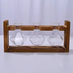 Set di tre beute di vetro con supporto in legno, perfette come decorazioni scientifiche o oggetti da collezione, ideali per appassionati di chimica e scienza.