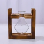 Beuta in vetro trasparente con supporto in legno, utilizzata per esperimenti scientifici e dimostrazioni di laboratorio.