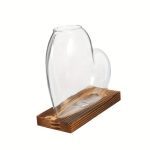Vaso di vetro trasparente con forma unica, posizionato su una base in legno, ideale come oggetto decorativo scientifico o da collezione.
